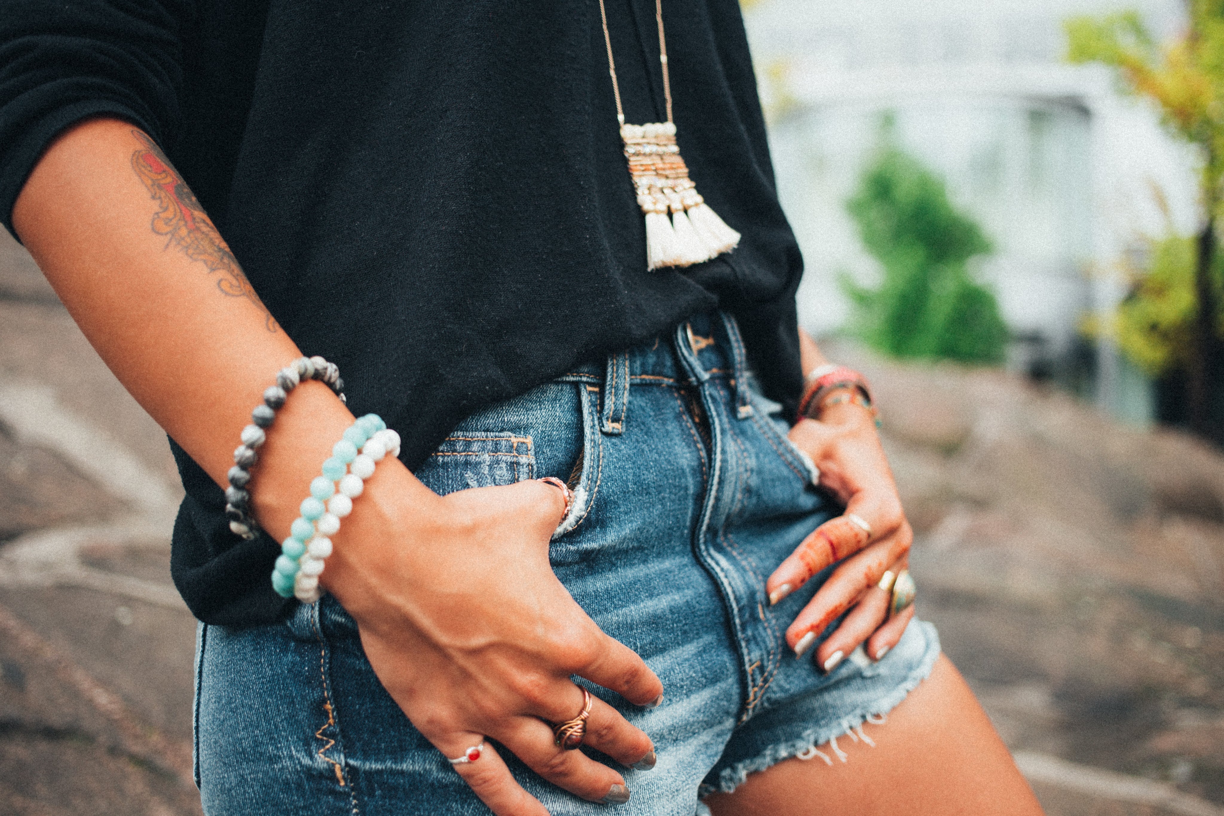 BOHO CHIC LIVING Collection by Pfresh, Woman wearing black loose top, denim shorts, bracelets and necklace.